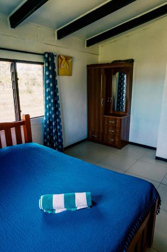 a blue bed with a blue and white pillow on it at Tovuka House Scuba too in Rakiraki