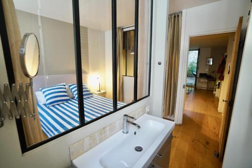 a bathroom with a sink and a mirror at T2 intra muros clim et cour ombragée in Avignon