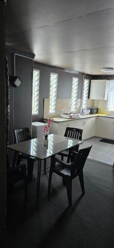 a dining room with a table and chairs and a kitchen at Haven Apartments- Nadi in Nadi