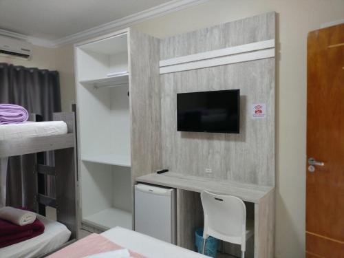 a room with a tv on a wall at Villarejo Parque Hotel in Penha