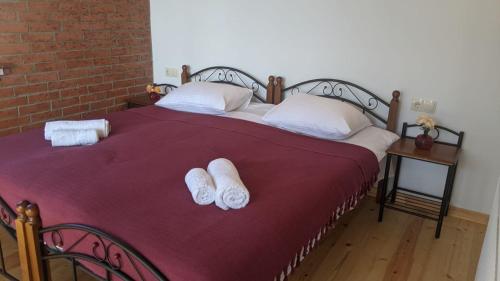 a bed with two pairs of white towels on it at Villa Maiseli in Ambrolauri