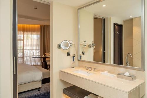 a bathroom with a sink and a large mirror at Lancaster Palace Tamuda Bay in Marina Smir