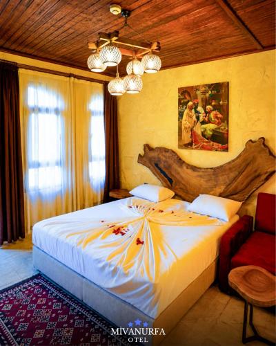 a bedroom with a large bed with a wooden headboard at MivanUrfa Otel in Urfa