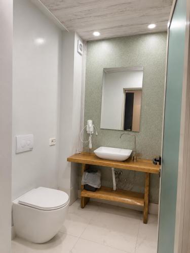 a bathroom with a toilet and a sink and a mirror at Shala Resort & SPA in Durrës