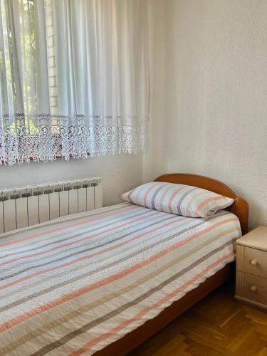 a bedroom with a bed and a window with curtains at Villa Zehra Ilidza in Sarajevo
