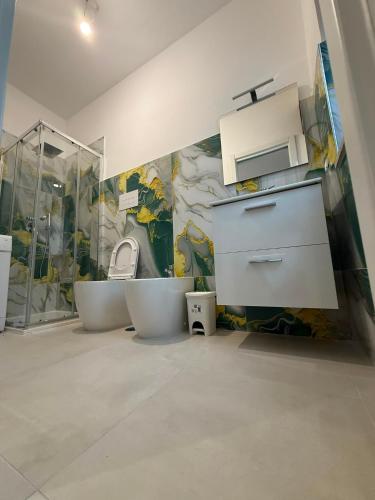 a bathroom with two white toilets and a mural at Angelo in Futani