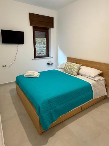 a bedroom with a large bed with a blue blanket at Angelo in Futani