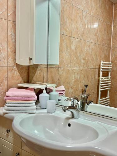 a bathroom with a sink and a mirror and towels at Villa Zehra Ilidza in Sarajevo