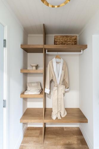 a dressing room with wooden shelves and a robe at Sand and Stone Resort in Huntsville