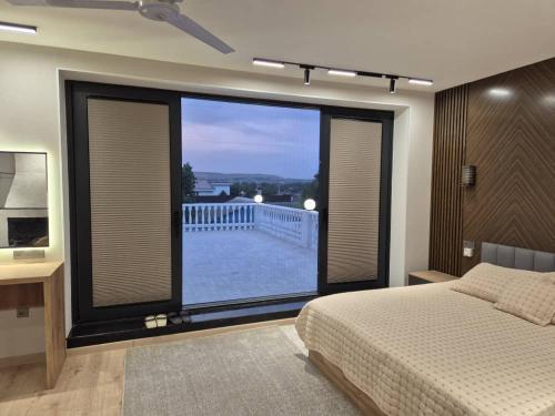 a bedroom with a large window with a view of a balcony at Villa by HomeLand in Khujand
