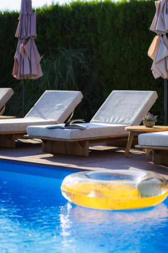 a pool with chairs and a yellow raft in the water at Villa Manevi in Yavornitsa
