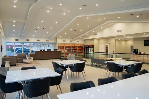 a cafeteria with tables and chairs in a library at Skye Hotel Ridgetown in Ridgetown