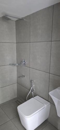 a bathroom with a white toilet and a sink at Lucy Residences in Ernakulam
