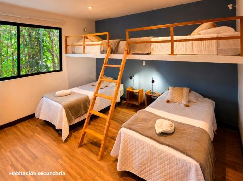 a bedroom with two bunk beds and a ladder at Principitos Universe in San Juan La Laguna