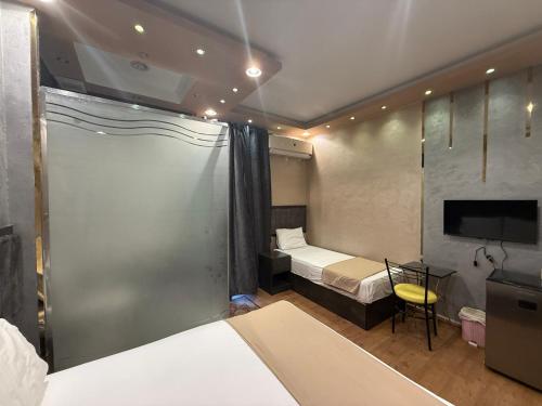 a hotel room with a bed and a tv and a bedroom at Cairò Plàza, Ravexa Hotel in Cairo