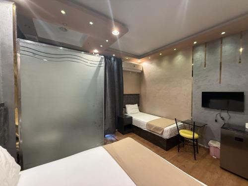 a hotel room with a bed and a tv and a bedroom at Cairò Plàza, Ravexa Hotel in Cairo