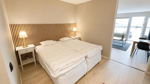 a bedroom with a large white bed and a desk at Terrasstudion - Borgholm in Borgholm