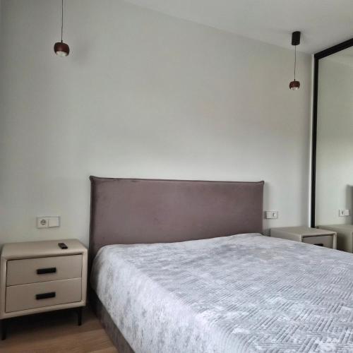 a bedroom with a bed and a nightstand next to it at Melnragė, Molo g in Melnragė