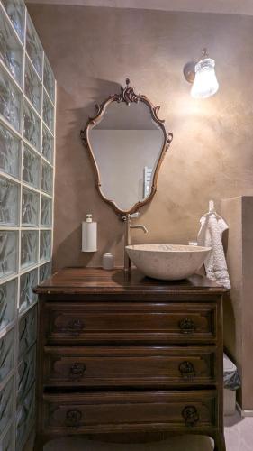 a bathroom with a sink and a mirror on a dresser at Château Foncine in Foncine-le-Bas