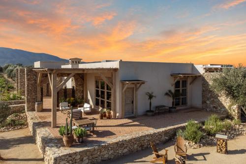 a house in the desert with a stone wall at Hábimo - Valle de Guadalupe in Valle de Guadalupe