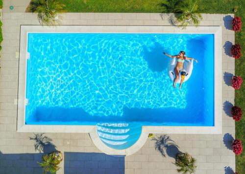 a woman riding a surfboard in a swimming pool at Vila DeLux in Negotin