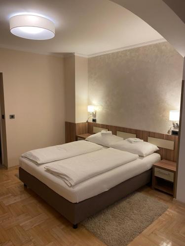 a bedroom with two beds in a room with a ceiling at Vila DeLux in Negotin