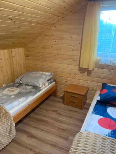 a small bedroom with a bed and a window at Dolina Nataci in Nidzica