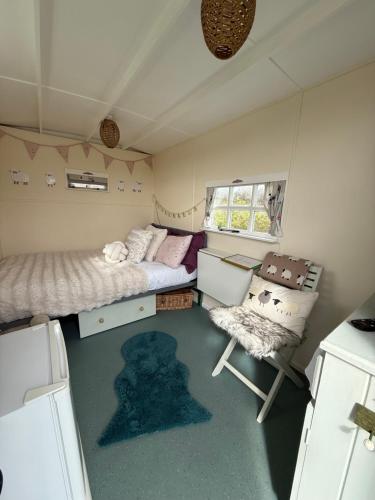 a small room with a bed and a chair at Hut 4 Ewe glamping pod with shared facilities in Bideford
