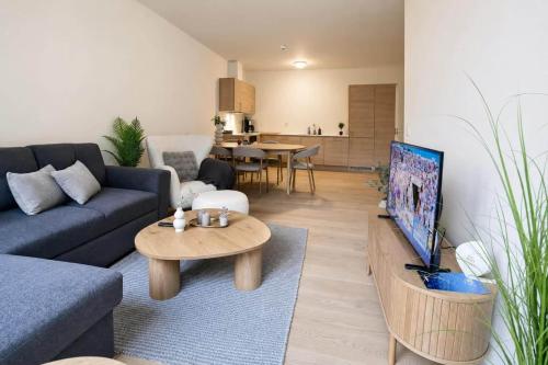 a living room with a blue couch and a tv at The Haven II - Cozy 2BR Voss - The Voss Collection in Vossevangen