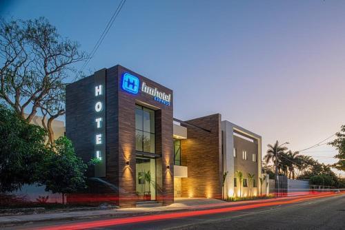 a building with a sign on the side of a street at Hm Express in Colima