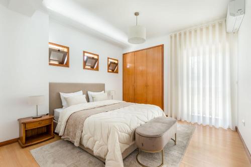 a white bedroom with a large bed and a window at Cinfães Centro Stay in Cinfães