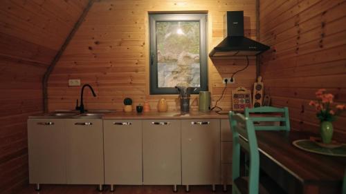 a kitchen with a counter with a sink and a window at Kesane Cottages in Racha in Oni