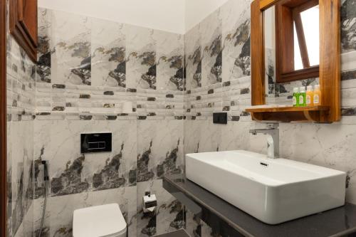 a bathroom with a white sink and a toilet at Sunset Heaven Boutique in Kandy