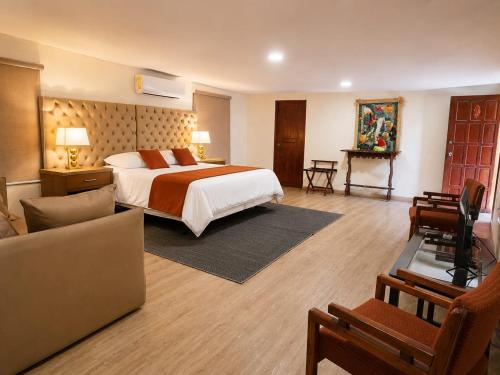 a bedroom with a bed and a living room at Hotel Rincón Vallero in Valle de Anton