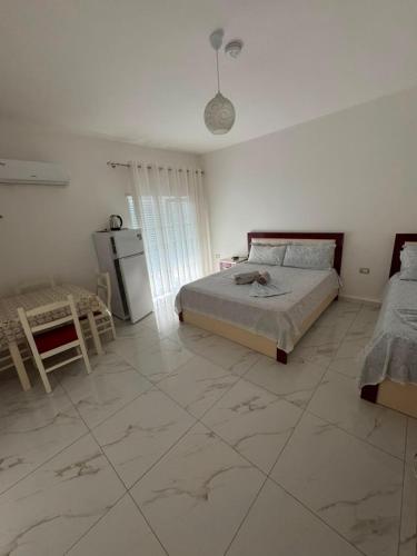 a white room with a bed and a refrigerator at Vila Ornela in Shëngjin