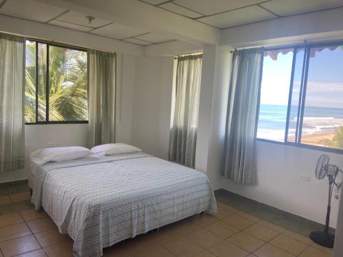 a bedroom with a bed with a view of the ocean at Hotel La Tolita in Atacames