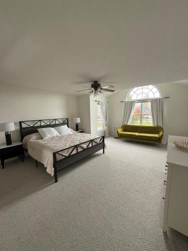 a bedroom with a bed and a couch and a window at 4BR Home with Private Cinema in West Henrietta