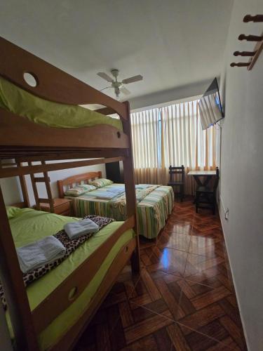a bedroom with two bunk beds and a table at Hostal COSTA AZZURRA in Cerro Azul