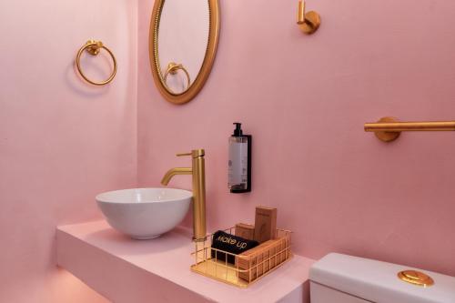 a bathroom with a white sink and a mirror at Aphrodite luxury rooms in Mytilene