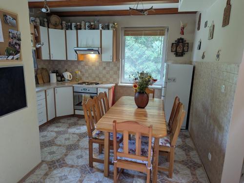 a kitchen with a wooden table with chairs and a refrigerator at Czerpak in Małszewko
