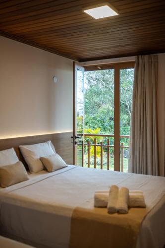 a bedroom with a bed with two towels on it at Casarão Alpina in Mucugê