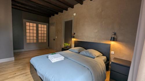 a bedroom with a large bed with blue sheets at Château Foncine in Foncine-le-Bas