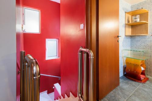 a bathroom with red walls and a red wall at Dolphins maisonette Rhodes in Ialysos