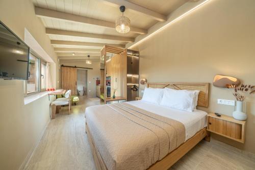 a bedroom with a large bed and a desk at Sea salt house in Zambelláta