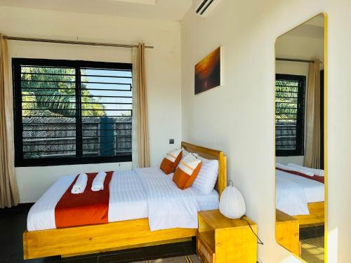 a bedroom with two beds and a large window at Shubbys Villa in Dar es Salaam