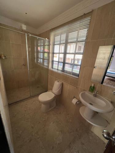 a bathroom with a toilet and a shower and a sink at Tangara Real Hotel Campestre in Quimbaya