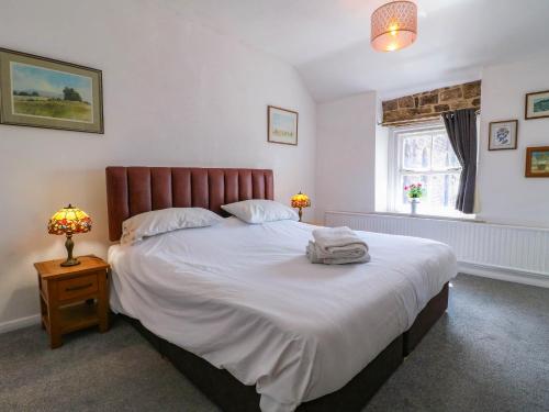 a bedroom with a large bed and a window at Jasmine Cottage in Matlock
