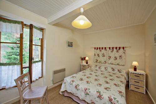 une chambre avec un lit, une chaise et une fenêtre dans l'établissement Auberge Lou Peyrol, à Montferrand-du-Périgord