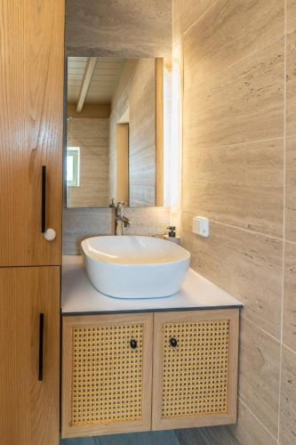 a bathroom with a white sink and a mirror at Sea salt house in Zambelláta