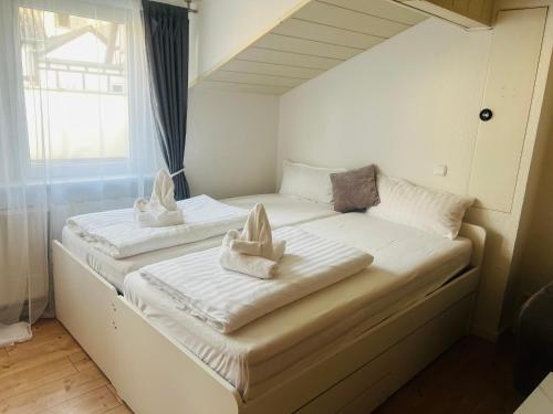two beds in a small room with towels on them at DADI Apartment in Linz am Rhein
